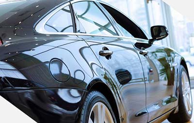 woman on phone looking at car damage